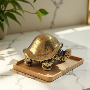 Antique brass dragon turtle figurine on a wooden tray with a natural marble background