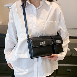 Close-up of black leather baguette bag featuring dual silver twist locks and a shoulder strap