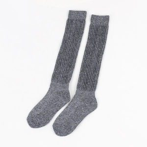 Detail of grey knitted slouch socks featuring thick vertical ribbing and cozy wool texture