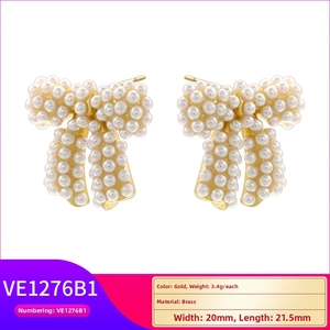 Detail view of gold brass bow earrings with white pearls and size dimensions 20mm x 21.5mm