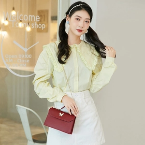Fashionable dark red chain bag with butterfly clasp styled with a yellow ruffled shirt