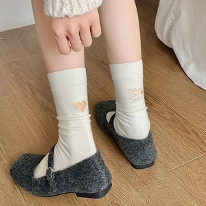 Detail of white cotton mid-calf socks with heart embroidery and Follow your heart text
