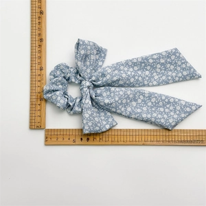 Blue floral print fabric scrunchie with large bow detail and 20cm length measurement