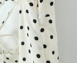 Detailed view of white polka dot dress with invisible zipper and delicate straps