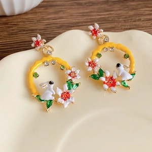 Vue détaillée des boucles d'oreilles vintage avec charms lapin et fleurs sur plateau
