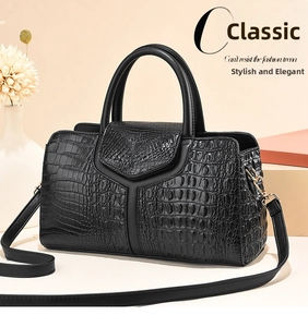 Detail of black crocodile embossed pillow handbag with V-flap and gold metal hardware