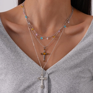 Vintage multilayered silver cross necklace with colorful zircons worn by a model