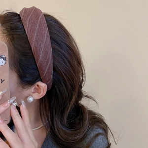 Detail shot of a dark brown herringbone fabric headband in a French retro style look