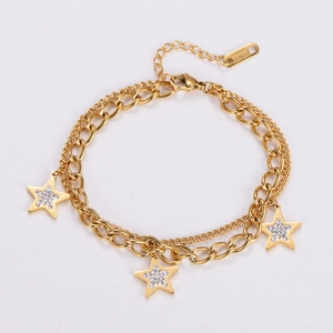 Detail of double-layer stainless steel gold bracelet with sparkling zircon star charms