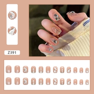 Détail des faux ongles Z391 avec dégradé nude et décorations métalliques argentées en 3D