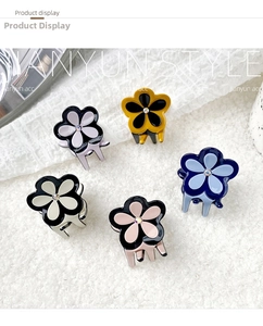 Gros plan de pinces à cheveux fleur en acétate avec centre en strass étincelant