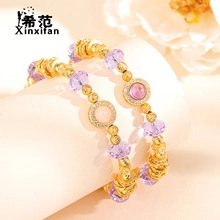 Detailed close-up of beaded bracelet with gold accents and faceted purple crystals
