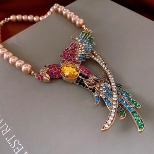 Detailed macro shot of vintage parrot pendant with colored crystals and pink pearls