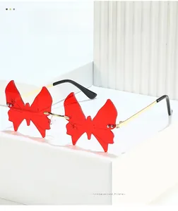 Macro detail of rimless butterfly sunglasses with red lenses and silver rivets