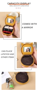 Detail of yellow cat-ear mini makeup bag showing built-in mirror and lipstick capacity