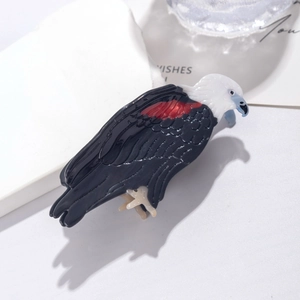 Detailed top view of a black eagle hair claw clip with white head and red wing accents