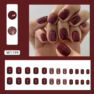 Short burgundy press-on nails with sparkling glitter accents in a 24-piece square set
