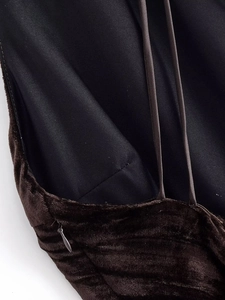 Detail of dark brown velvet dress showing side invisible zipper and thin shoulder straps