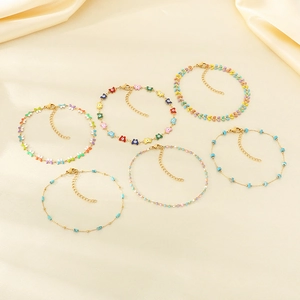 Detail of bohemian gold chains with colorful butterflies, flowers and turquoise beads