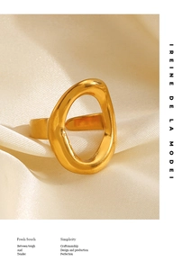 Macro shot of gold irregular oval hollow ring on beige silk background with luxury finish