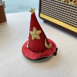 Détail d'une pince à cheveux chapeau de sorcière rouge pailleté avec étoile dorée