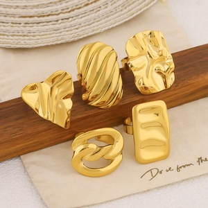 Set of 18k gold geometric rings with heart and square textured designs on display