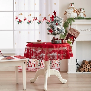 Detailed close-up of festive red lace Christmas tablecloth with intricate holiday patterns