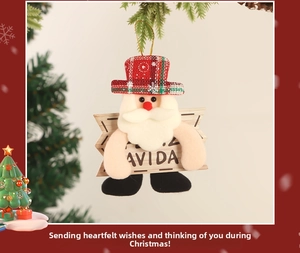 Detail of fabric Santa ornament with red plaid hat and wooden sign on Christmas tree