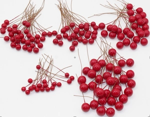 Close-up of bright red artificial berries with flexible brown stems for DIY decor