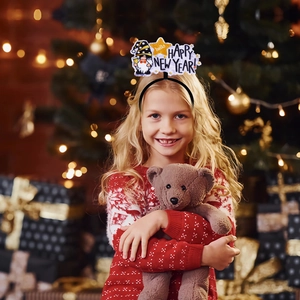 Festive Happy New Year headband with cute gnome and yellow star on a girl in red sweater