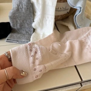 Detailed close-up of hollow flower patterns and mesh texture on cotton crew socks