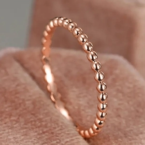 Dettaglio macro di un anello a sfere minimalista oro rosa su scatola per gioielli