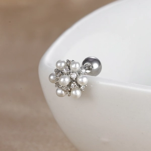 Détail macro d'une boucle d'oreille fleur en perles avec fermoir à bille et finition argent