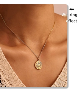 Gros plan du collier avec pendentif œil porte-bonheur doré et émail coloré sur un mannequin