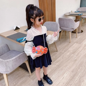 Détail d'un mignon sac bandoulière orange en forme de bonbon porté par une petite fille