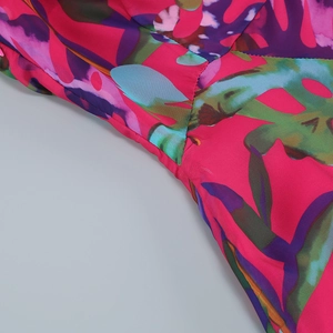 Detailed view of floral textile fabric with pink botanical print and neat side seam stitching