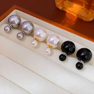 Three pairs of elegant double pearl stud earrings in grey, white, and black with metallic finish