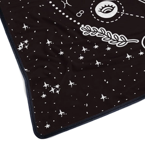 Close-up of soft black flannel blanket featuring white mystic star and eye patterns