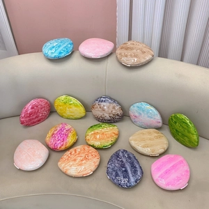Detailed macro view of colorful marble patterned portable oval cases in vibrant pastel shades