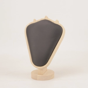 Detail of dark gray velvet necklace display bust with natural wooden base on white background