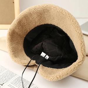 Detail of warm lamb wool bucket hat featuring black quilted lining and adjustable drawstring