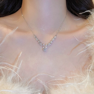 Detailed view of zircon flower pendant necklace with elegant leaf design on feather background