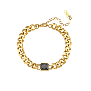 Macro detail of 18K gold-plated Cuban chain link bracelet featuring a black square zircon