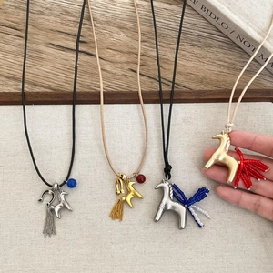 Adjustable horseshoe pony tassel necklace with bead detail in minimalist western style
