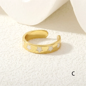 Detail shot of golden adjustable ring featuring white star patterns and polished finish