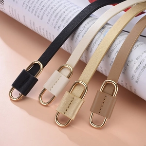 Set of four minimalist thin leather belts with gold oval buckles in black and white