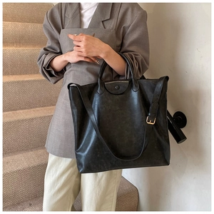 Detail van de matgrijze tote bag met verstelbare schouderriem en drukknoopsluiting