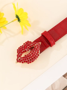 Close-up of red crocodile pattern leather belt with a rhinestone lip-shaped buckle