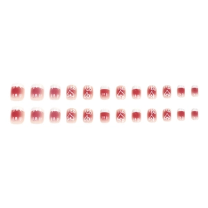 French tip press-on nails with pink blush gradient and hand-drawn white heart patterns