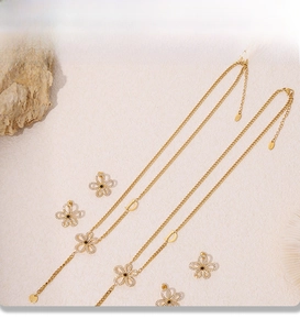 Macro detail of 18k gold plated floral jewelry set with zircon and D-letter pendant